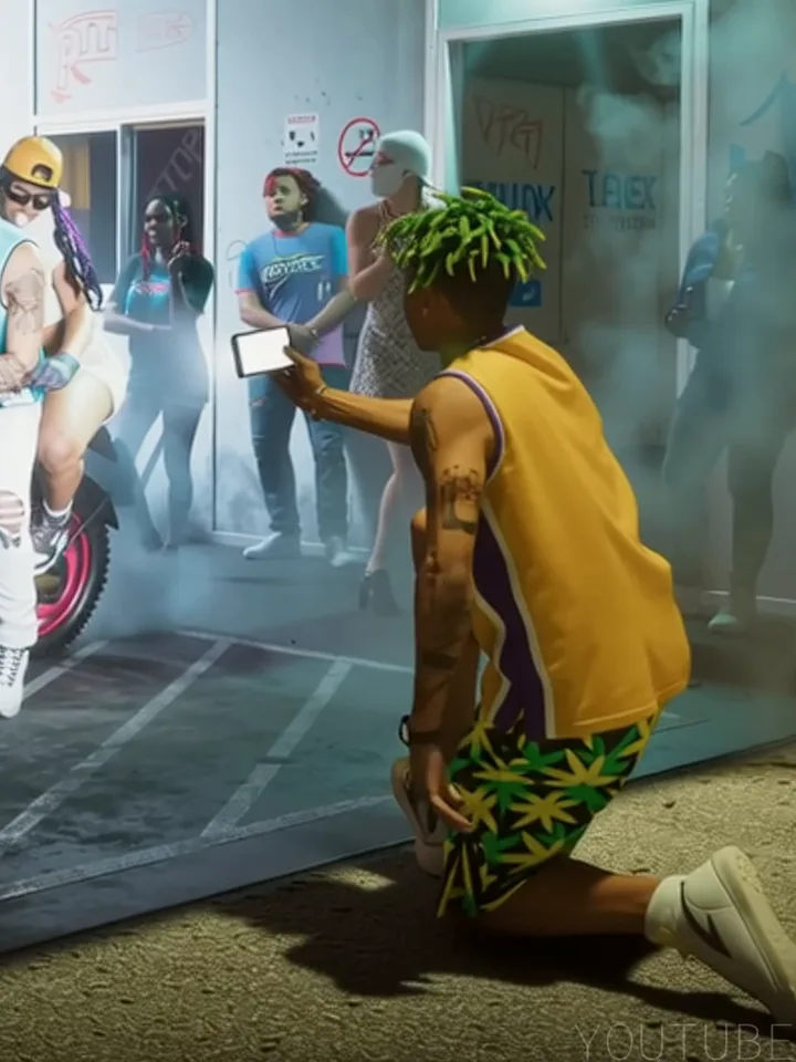 El joven de las rastas verdes grabando con el móvil
